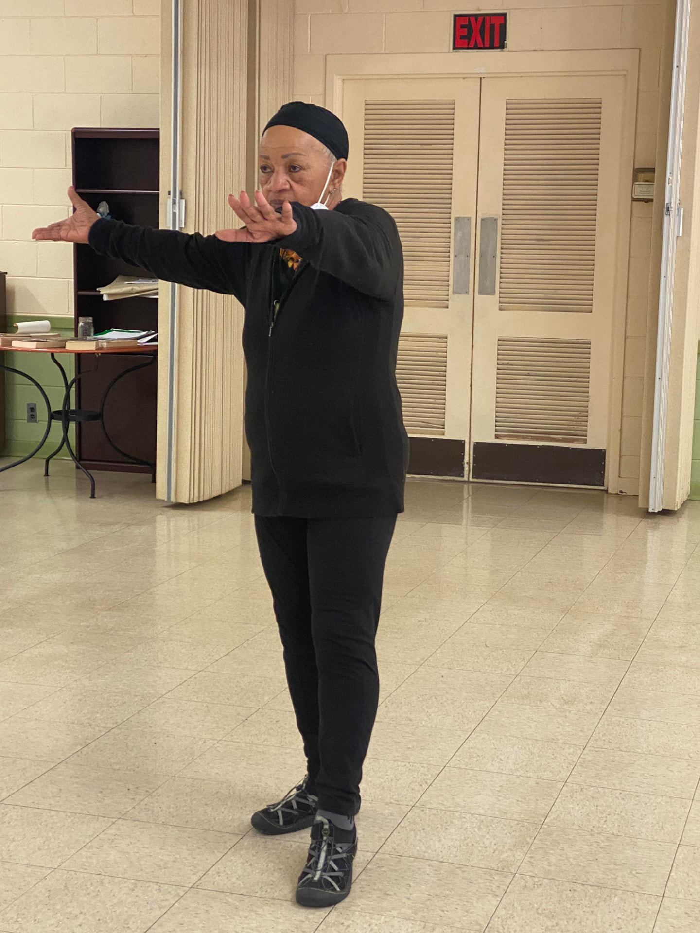 Ms. Ruth DeRamus practicing Tai Chi, arms extended in an open stance